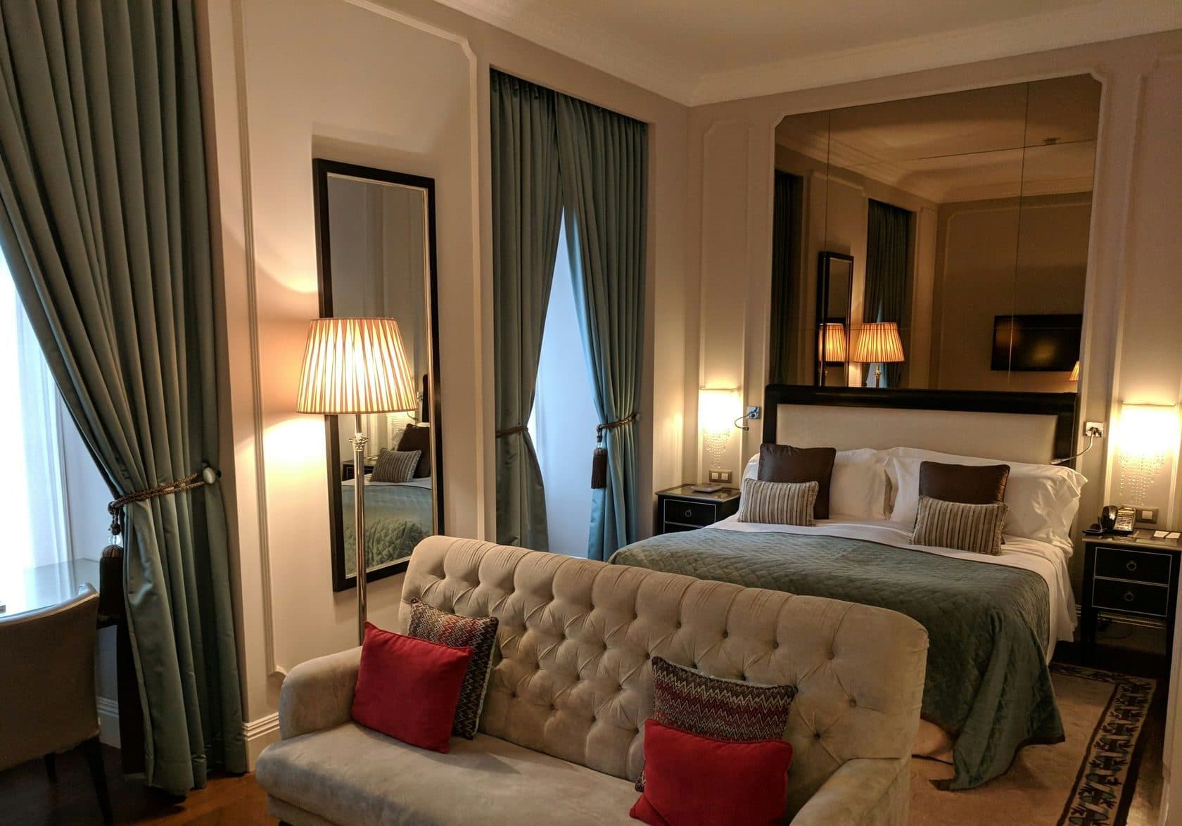 Hotel guest room with a made bed, curtains and a sofa